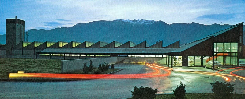 The PLANK factory in Ora at dusk, with light trails of passing cars
