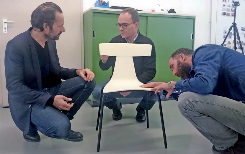 Konstantin Grcic und zwei Männer hocken um einen REMO mit weißer Schale auf schwarzen Beinen